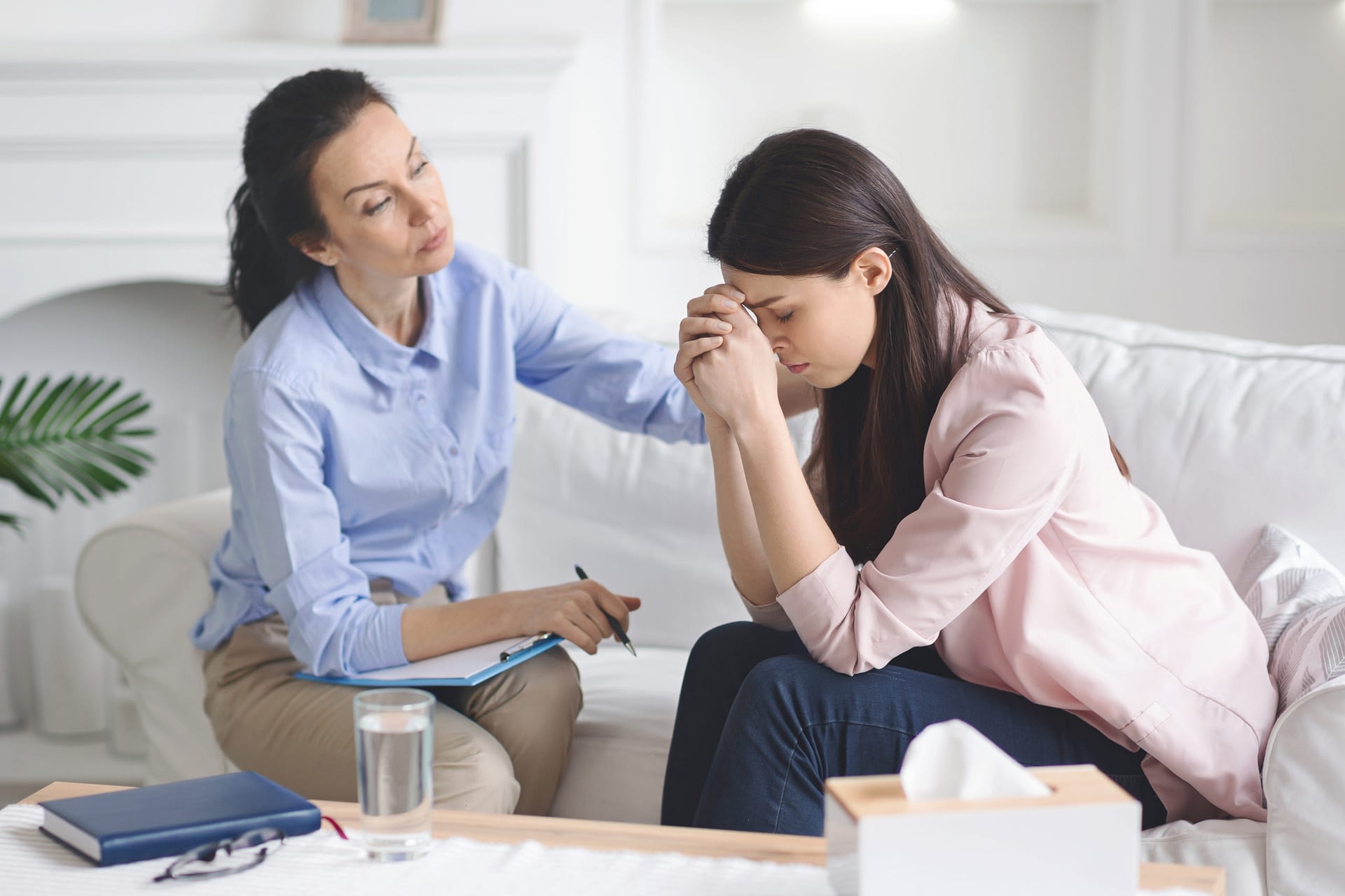 Therapist comforting her depressed crying woman patient