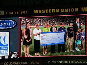 Representivies from five charities accepting grants on the field at the Rapids game on August 17th