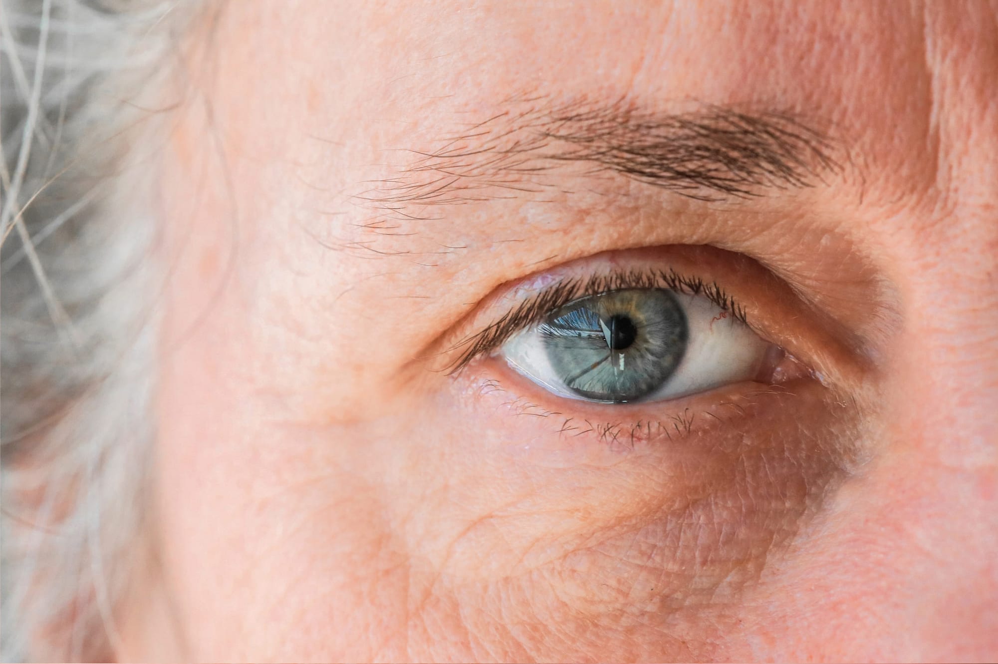 close up of macro shot elderly man two brown eyes with pupil and