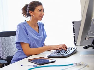 Medical Coder In Office Working At Computer