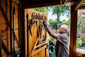 Man selecting garden tools in shed