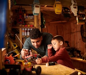 Dad and son working in shed together