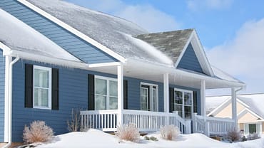 Home With Blue Siding In The Snow