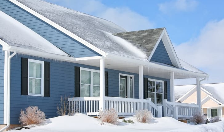 Home With Blue Siding In The Snow