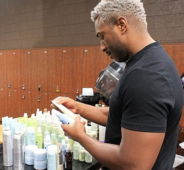 male esthetician student looking at Aveda skin care products