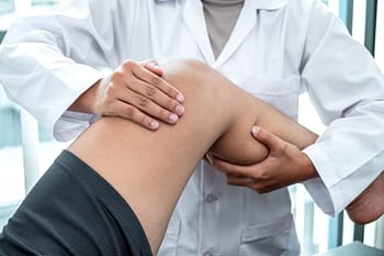 Doctor examing patients knee