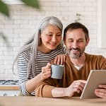 Smiling middle-aged couple looking at a tablet for new home
