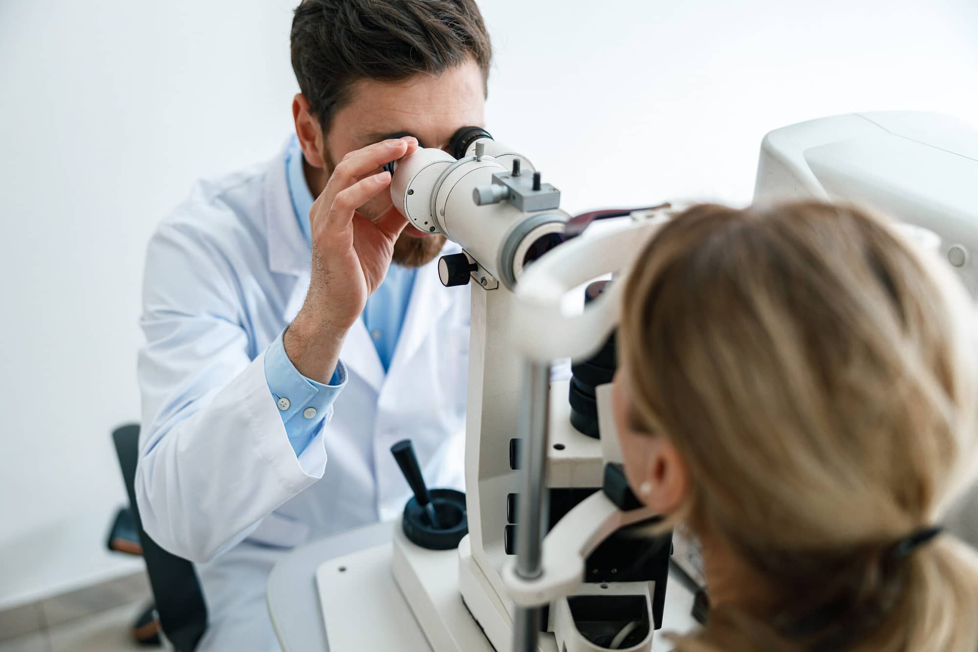 Optometrist checks the patient’s intraocular pressure in optician’s shop or ophthalmology clinic
