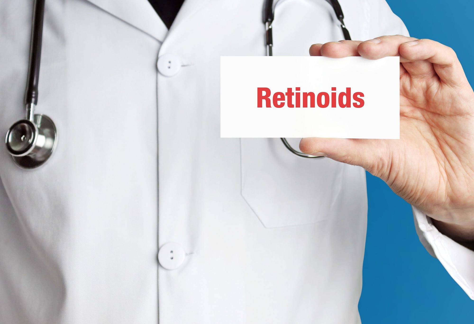 Retinoids. Doctor in smock holds up business card. The term Reti
