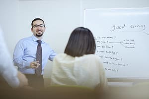 Teacher at whiteboard instructing an English language class