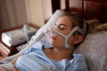 Woman using CPAP machine to sleep