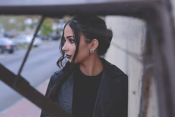 woman with her hair in a bun standing outside