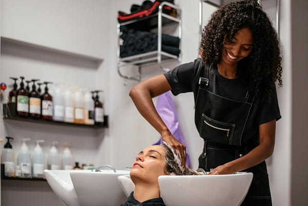 Woman washing another woman's hair in salon