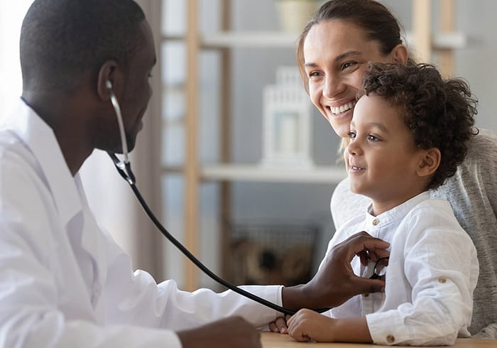 Doctor with a stethoscope examines a young boy.