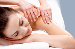 Massage therapist places hands on shoulder of client