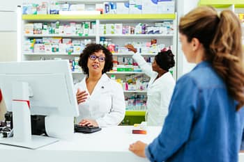 Pharmacy technician interacts with client 