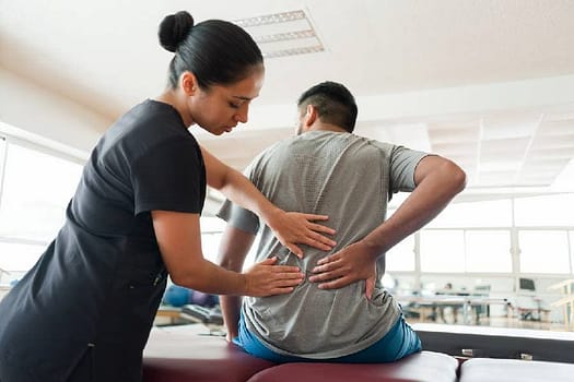 A clinical massage therapist examines a client’s back
