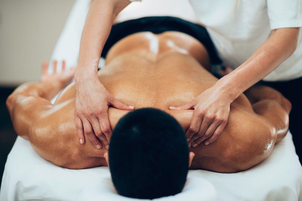 Massage therapist massaging client’s back