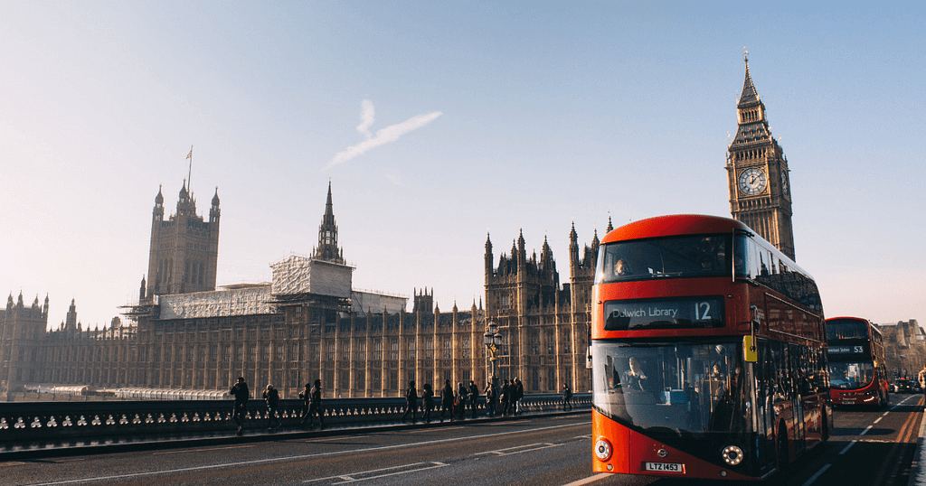 Shot of Big Ben, a double decker bus, and the Houses of Parliament in London.
