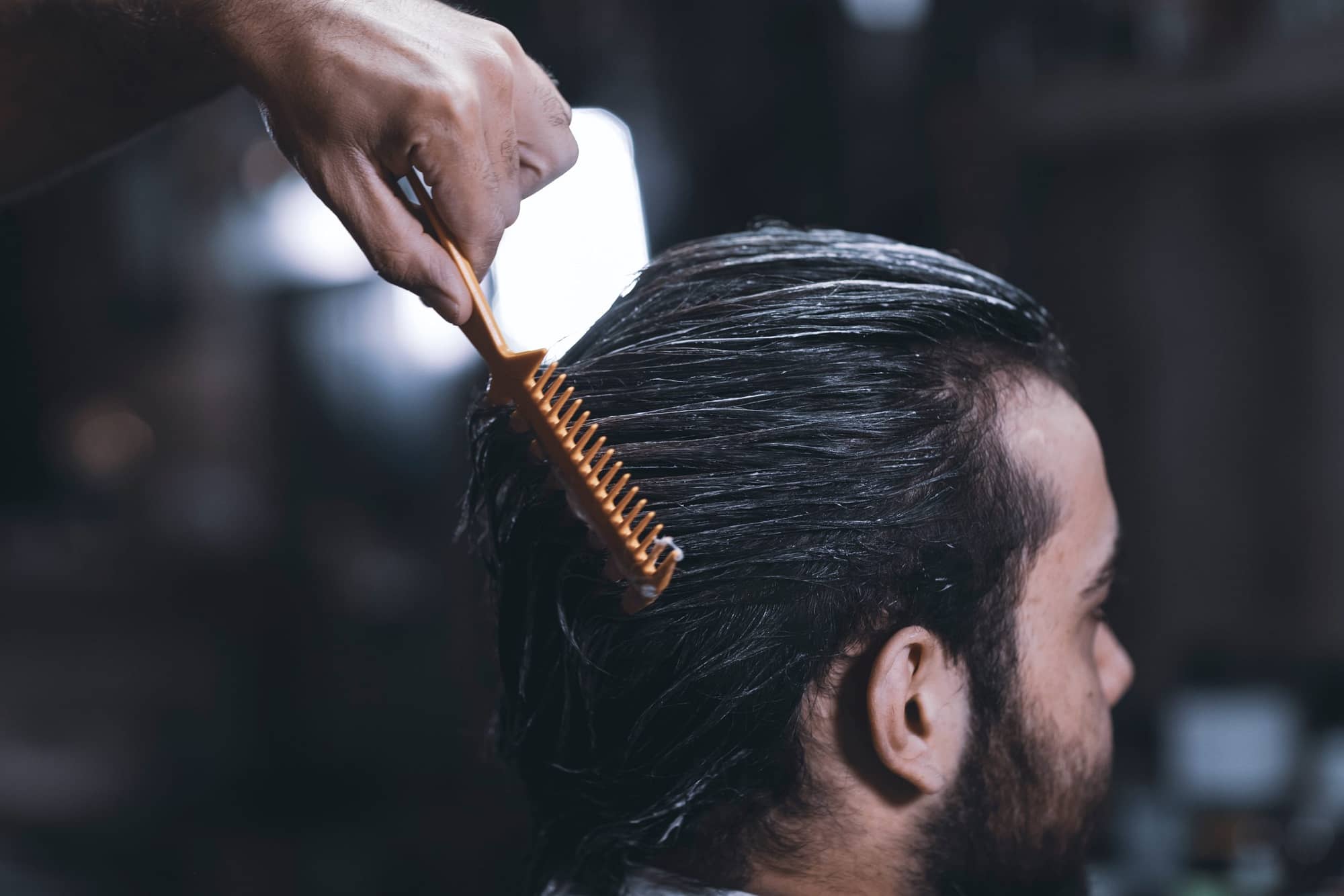 A barber combs a man’s hair