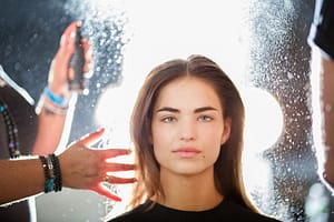 Woman getting her hair sprayed by a stylist