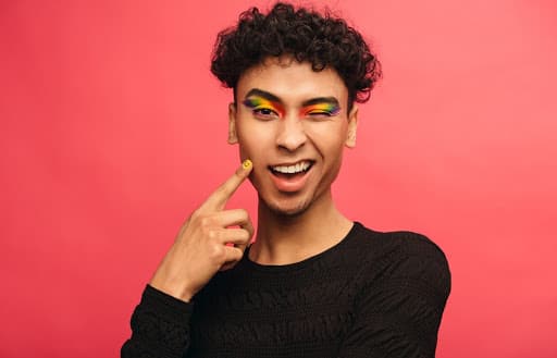 man with rainbow eyeshadow and smiling