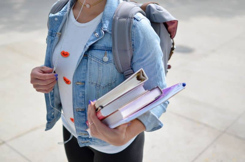 girl holding textbooks for beauty school