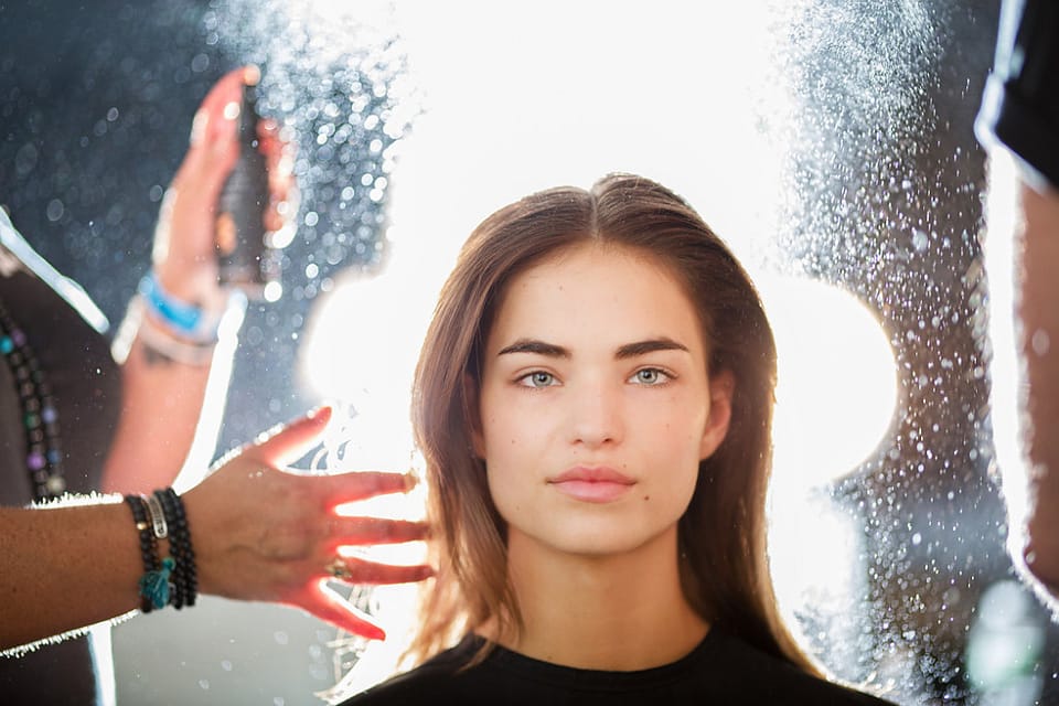 Woman getting her hair sprayed by a stylist