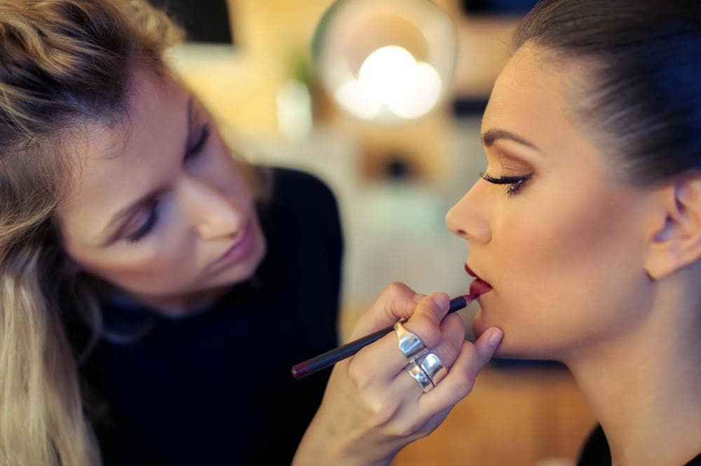 A makeup artist working on a model.