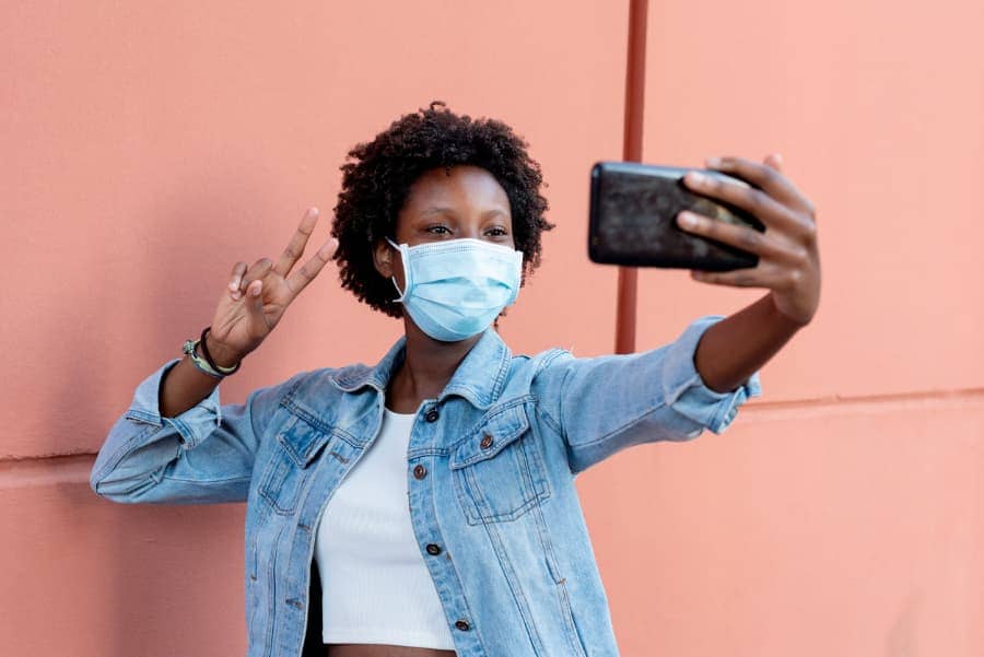 woman in a mask taking a selfie with cellphone