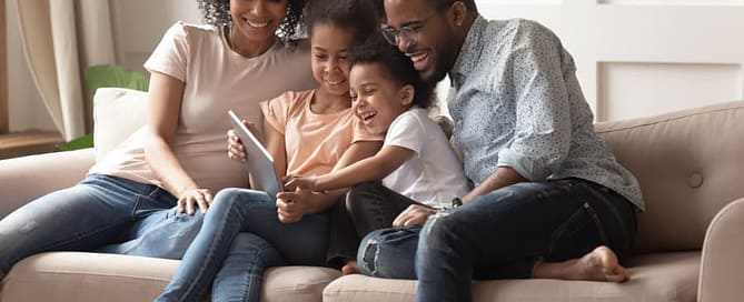 Happy family on a couch looking at tablet