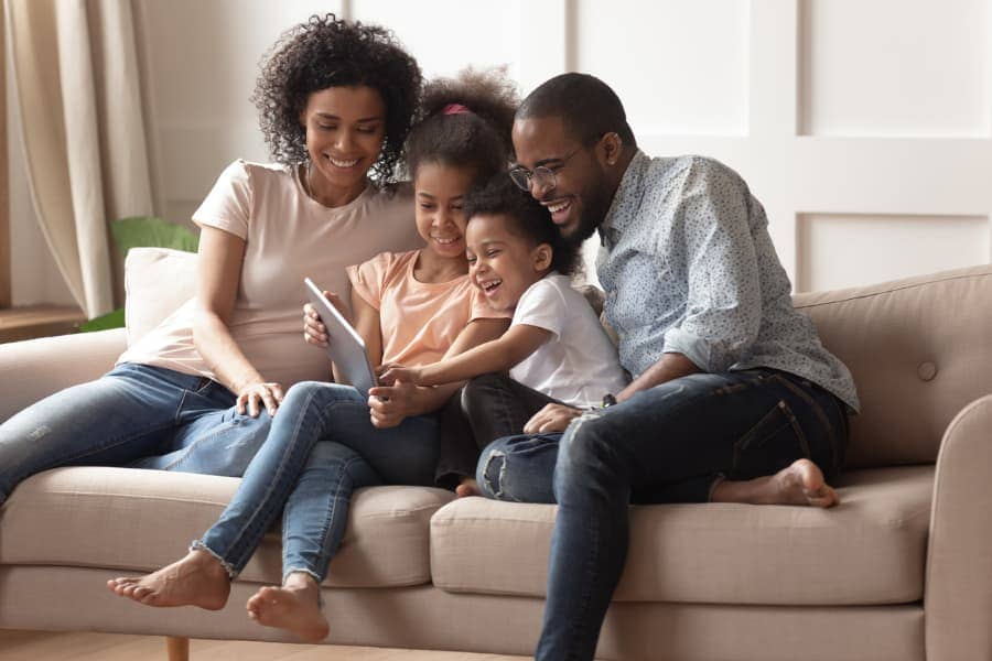 Happy family on a couch looking at tablet