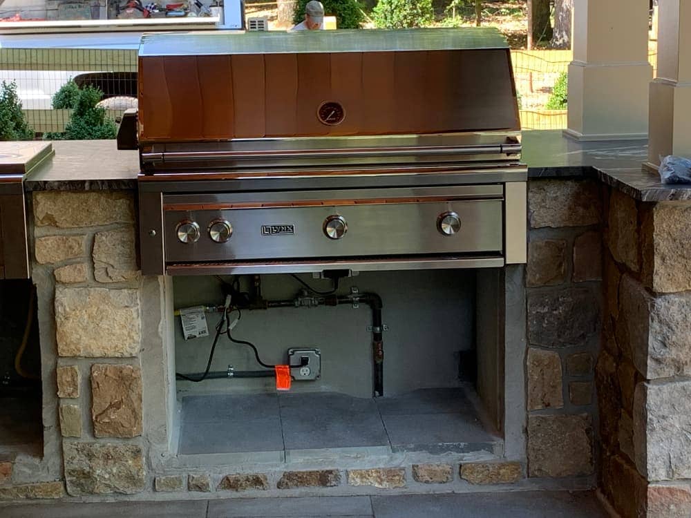 Outdoor gas grill with pipe exposed underneath