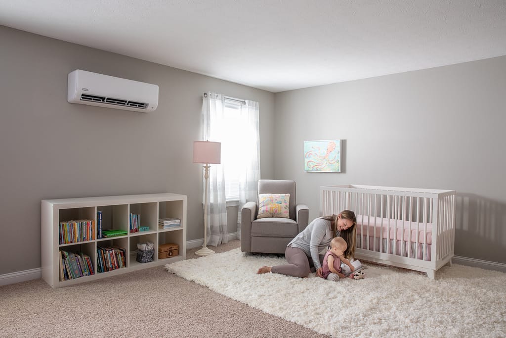 Mother and child in nursery with ductless system on wall