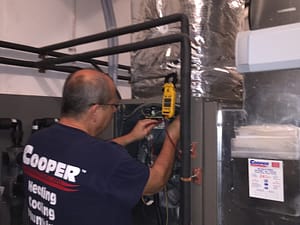 Cooper Mechanical Technician Repairing AC System In Basement