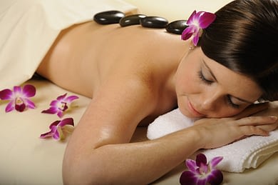 woman receiving a hot stone massage at a spa