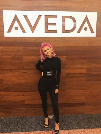 Allison Olean in front of the Aveda sign.