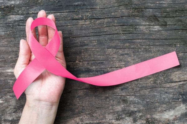 female hand holding a breast cancer awareness ribbon