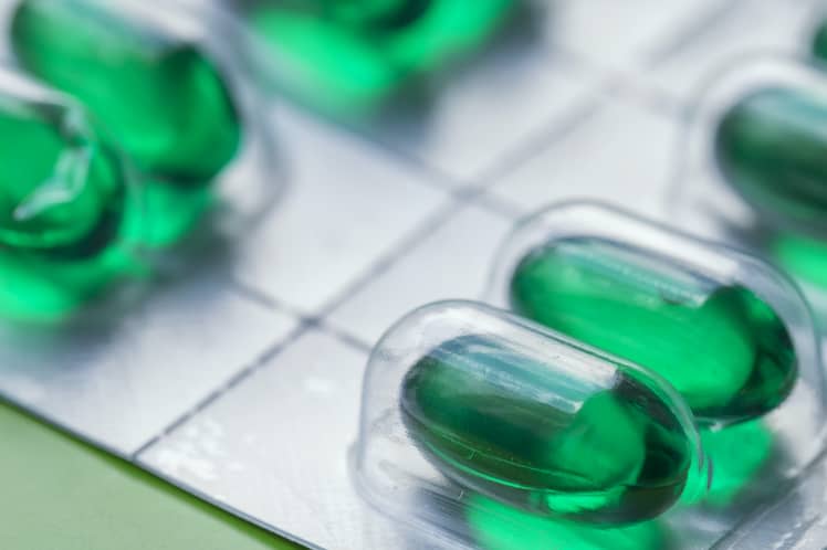 Green gelatin capsules. Pills