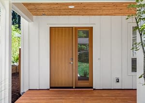 Entryway of home with white board and batten siding