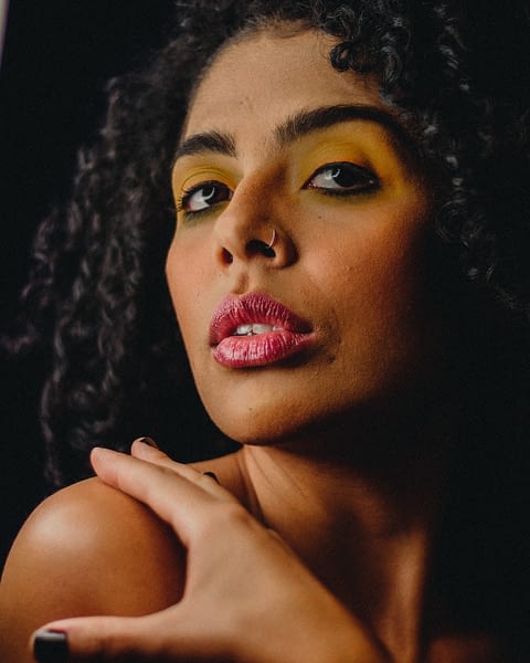 close up portrait of woman wearing yellow and pink makeup