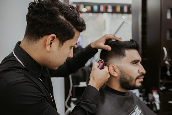 man trimming another man's hair