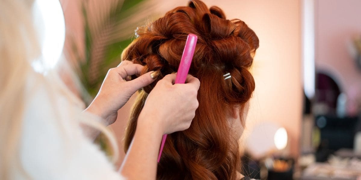 Red haired young woman getting hair curled