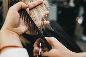 Stylist cutting hair with comb
