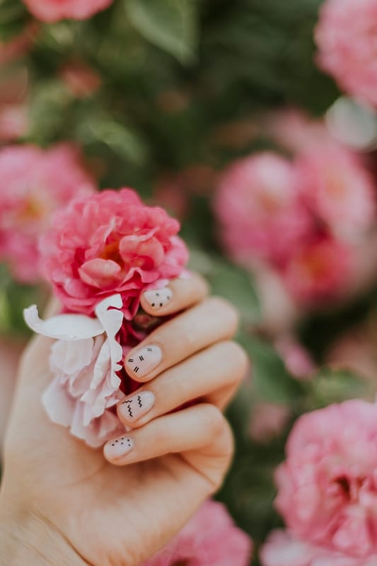 Nail art on light pink nails with floral background