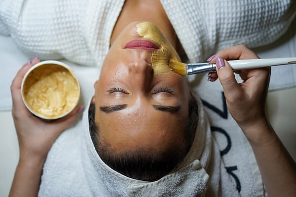 woman getting a face mask at a spa