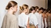 A line of Aveda models, dressed in white