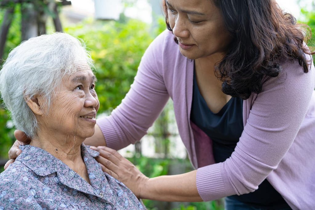 Caregiver helping senior woman outside
