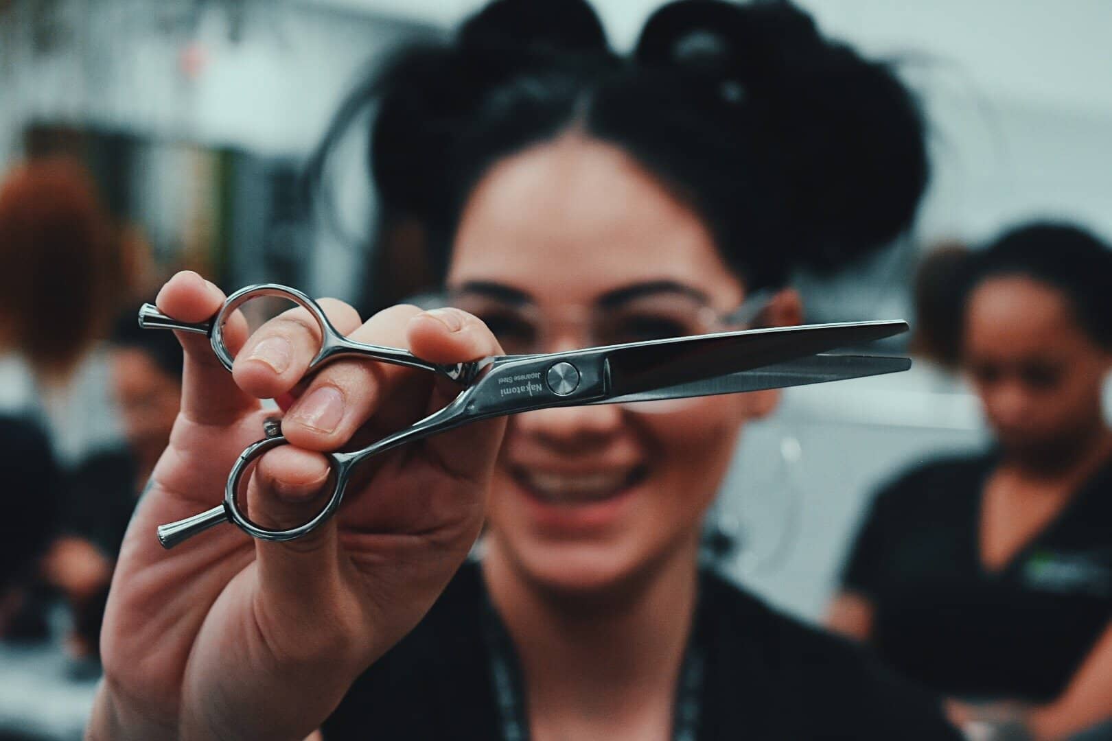 cosmetologist holding out pair of scissors