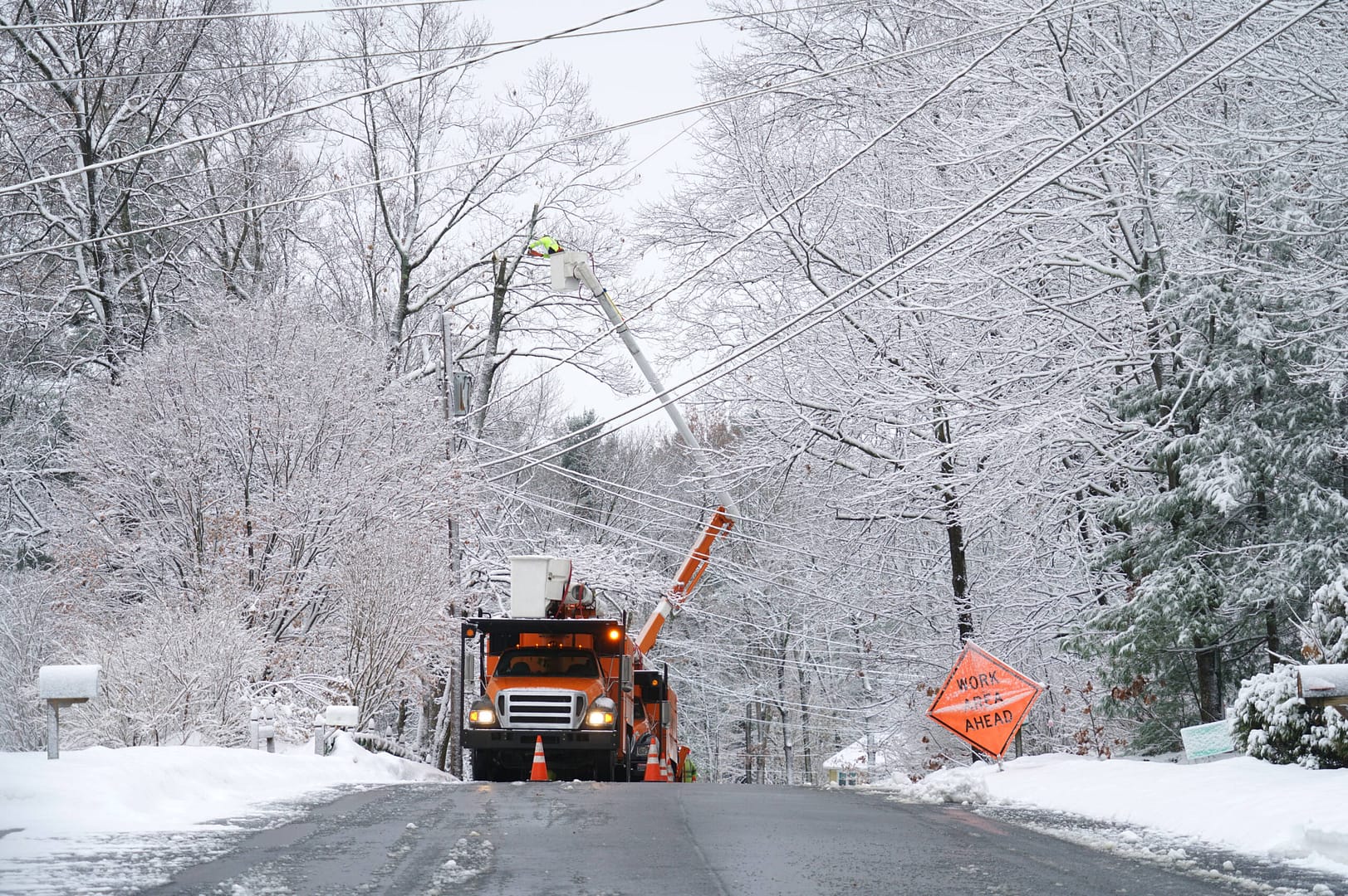A utility worker clearing an above-ground powerline line after a winter storm in Township, NJ.